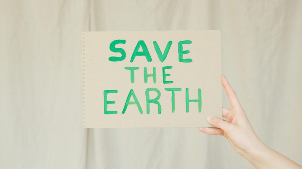 Een kartonen bord met 'save the earth' op 