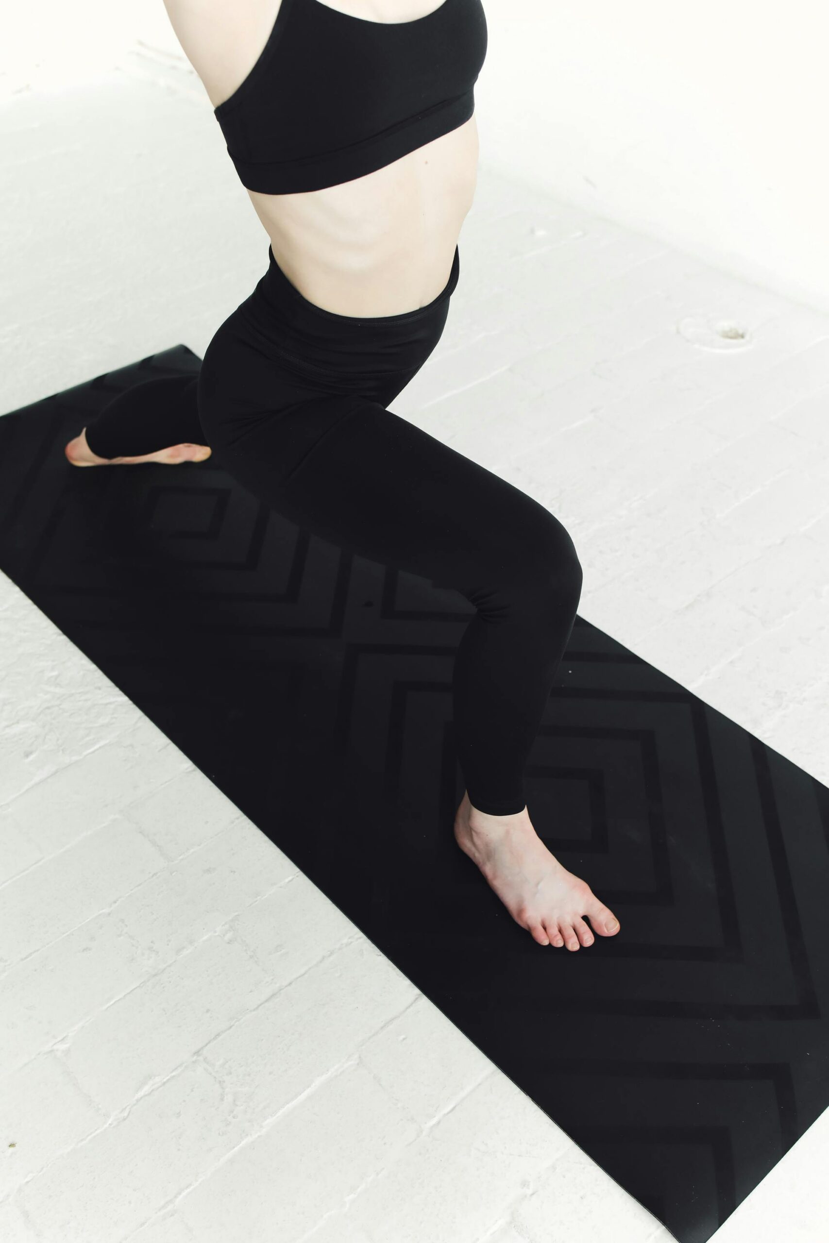 Een zwarte uitgerolde Yoga mat met anti slip.
